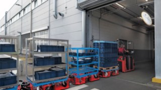 Tažná souprava LT10 WX od společnosti Linde Material Handling přepravuje materiál mezi dvěma halami