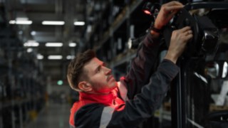 Světelné a výstražné systémy Linde Material Handling umožňují bezpečnou a přesnou manipulaci. Servisní technik Linde při montáži řešení osvětlení