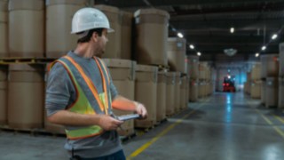 Interaktivní výstražná vesta od společnosti Linde Material Handling zajišťuje vyšší bezpečnost Skladník nosí interaktivní výstražnou vestu od společnosti Linde Material Handling ve tmavém skladu
