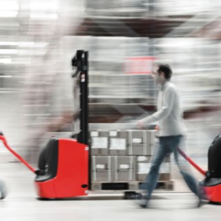 Vysokozdvižný ručně vedený vozík od společnosti Linde Material Handling naložený zbožím Vysokozdvižný ručně vedený vozík od společnosti Linde Material Handling naložený zbožím