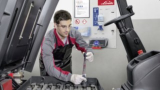 Využívejte výhod smlouvy o kompletním servisu pro energetický systém použitého vozíku Linde Servisní technik kontroluje pohonnou baterii použitého vozíku Linde