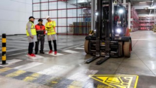 Poradenská schůzka s několika lidmi v tovární hale. Poradenská schůzka s několika lidmi v tovární hale.