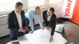 Odborníci ze společnosti Linde Material Handling při práci ve společnosti Yanmar Compact Equipment Europe. Odborníci ze společnosti Linde Material Handling společně plánují výstavbu logistického střediska společnosti Yanmar Compact Equipment Europe.