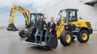 Dominik Haag a Markus Köhler ze společnosti Yanmar Compact Equipment Europe Dominik Haag a Markus Köhler ze společnosti Yanmar Compact Equipment Europe stojí ve lžíci rypadla.