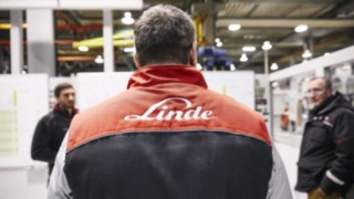 Zaměstnanec společnosti Linde s logem Linde na bundě