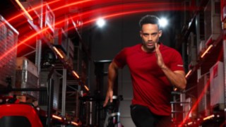 Sportovec běží ve skladu, v pozadí je vidět retrak Ri16 od společnosti Linde Material Handling.