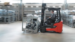 Skupina lidí analyzuje pracovní prostředí v logistické hale.